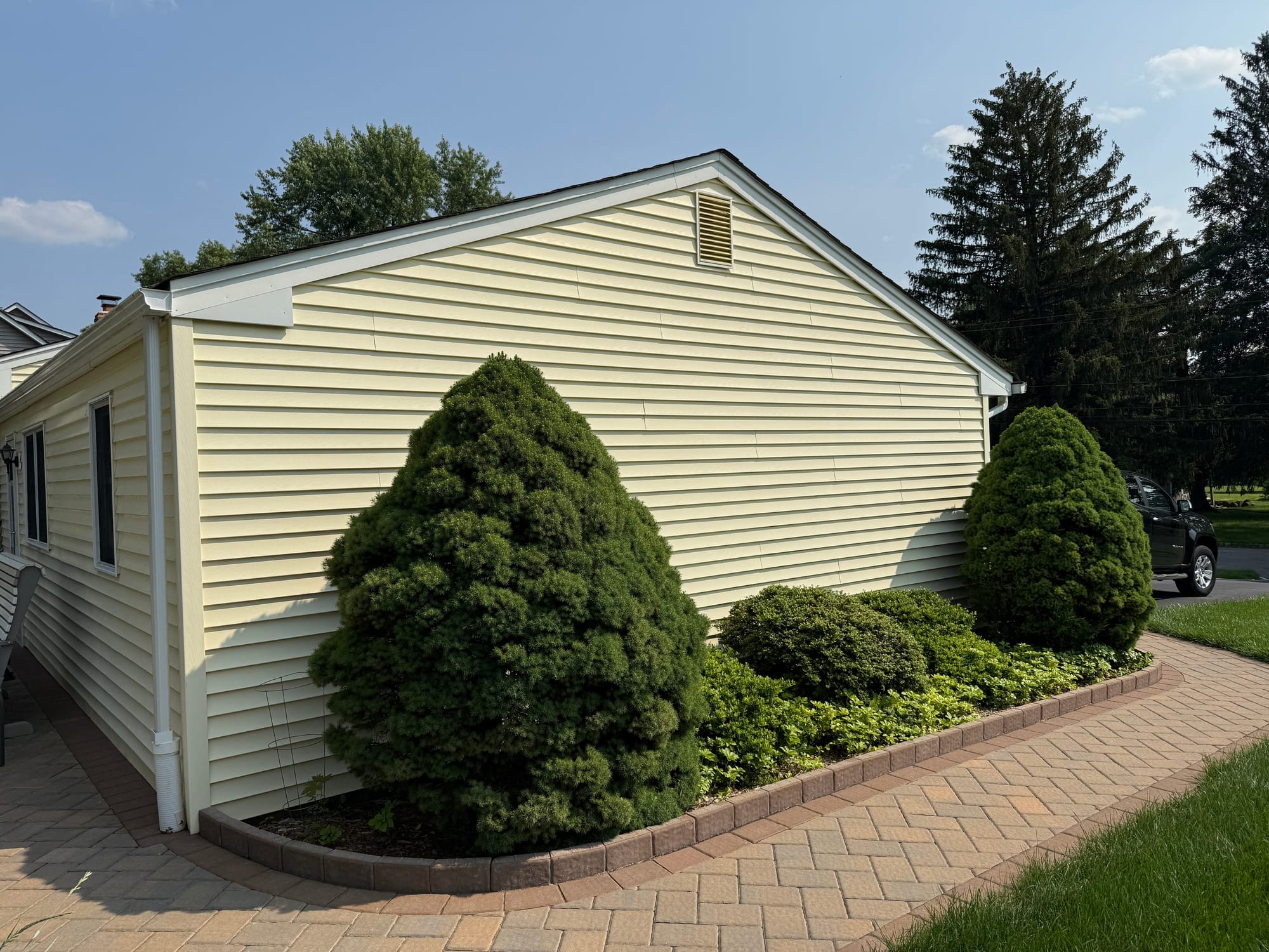 Before: gable end in the original pale yellow vinyl with blue shutters and gable vent