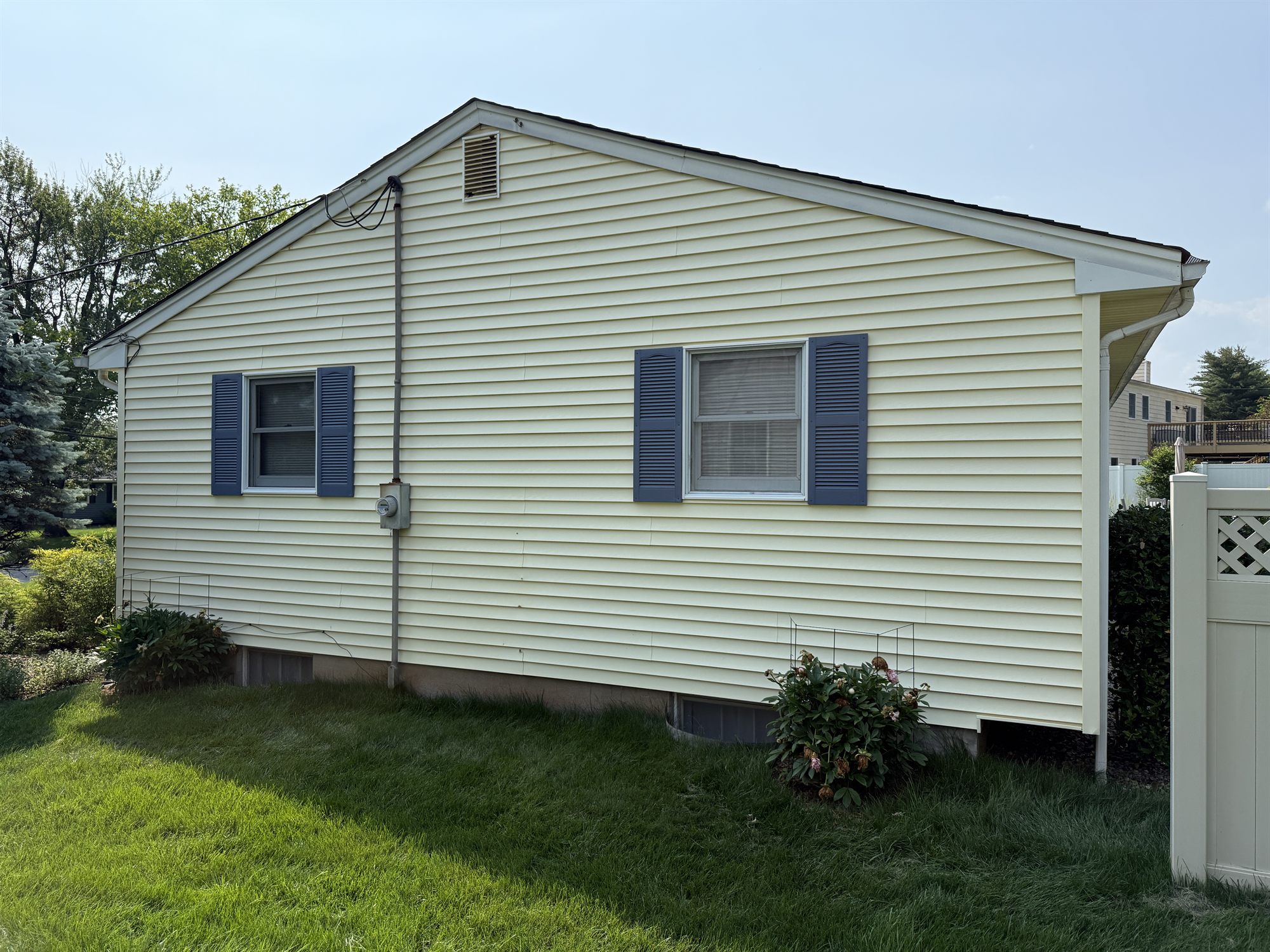 Before: rear elevation over the patio, original siding behind the seating area