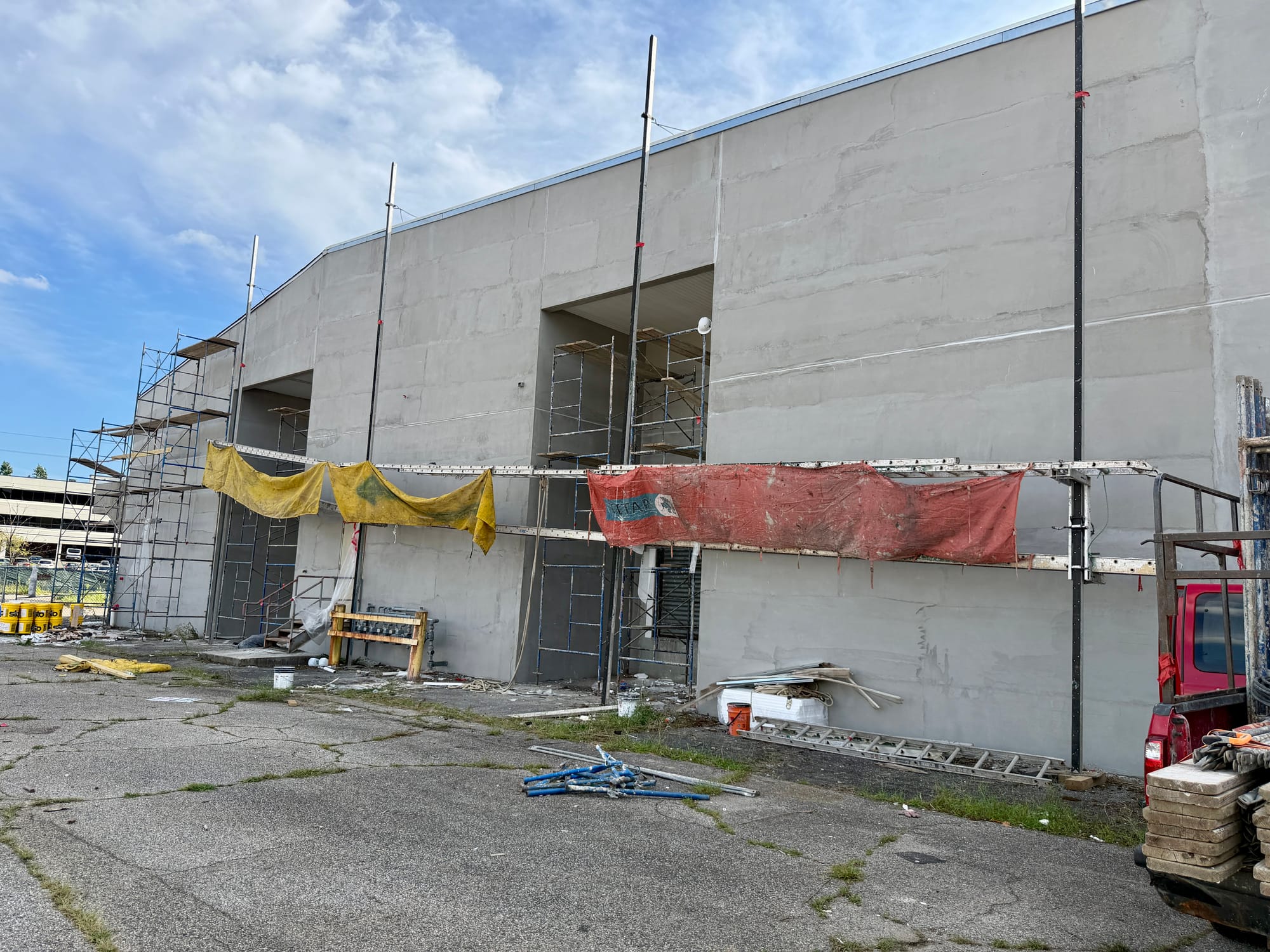 Scaffold along the side elevation, protection sheeting hung and the wall prepared ahead of the new finish