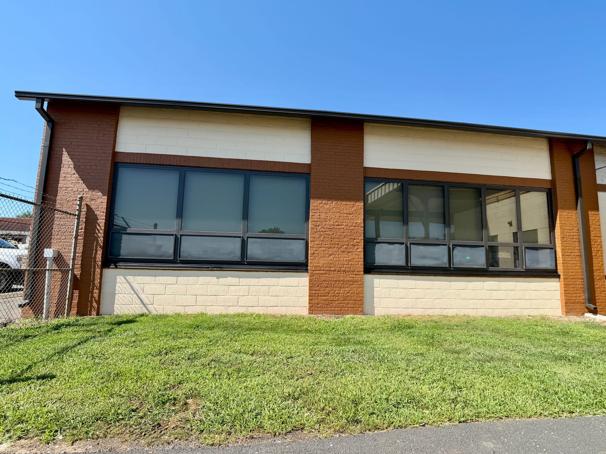 After: the finished side elevation, new coating carried across the block field and every window resealed