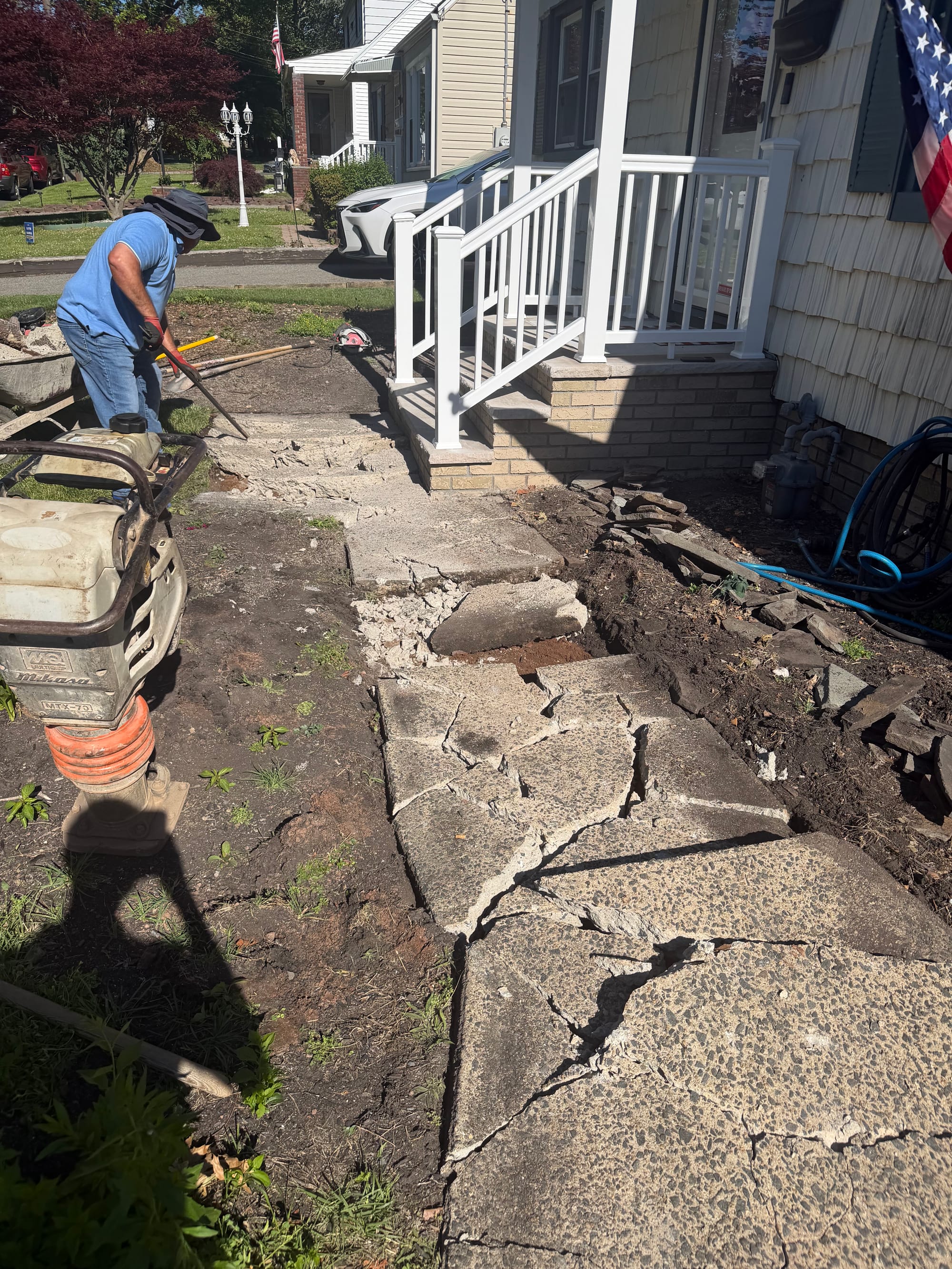 Before: the old walk being cut out, the failed sections lifted clear of the approach to the steps