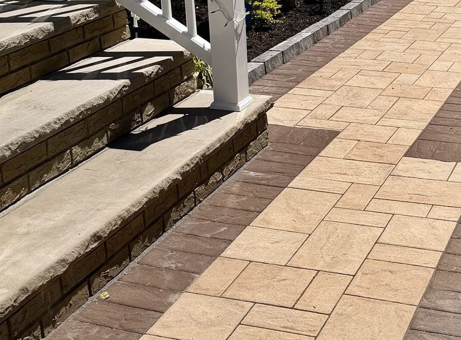 The walk meeting the porch steps, border course returning square against the risers